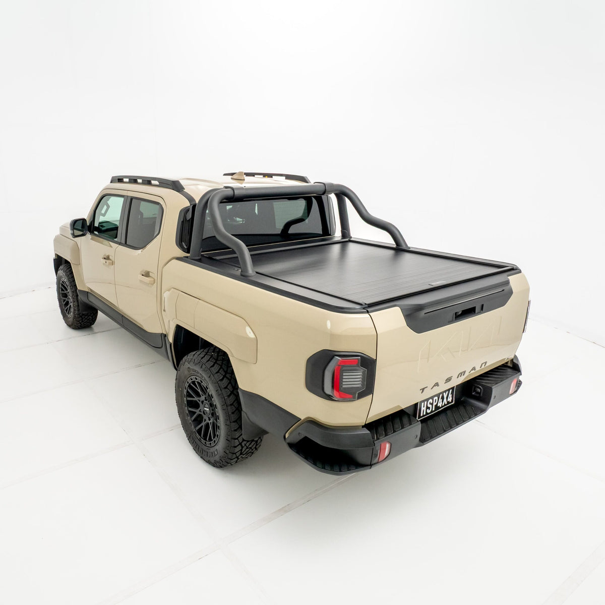Angled rear view of a Kia Tasman fitted with an HSP Roll R electric roller cover in the closed position with black sports bars mounted behind the cab.