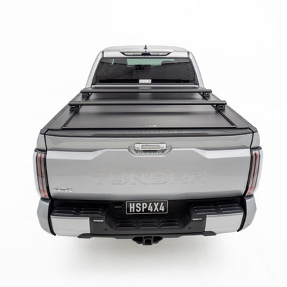 HSP Load Bars fitted over closed HSP Roller Cover on grey Toyota Tundra, rear view showing rack compatibility and secure tub coverage